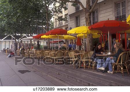 Stock Photo -  outdoor cafe, Paris, France, Europe, Beaubourg, People sitting under red and yellow umbrellas at an outdoor cafe at the Georges Pompidou Centre in Paris.. Fotosearch