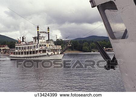 Stock Photo -  paddlewheel, boat, Lake George, Adirondacks, New York, Adirondack Park, The Minne-ha-ha Paddlewheel tourboat cruises slowly along the waterfront of Lake George in the village of Lake George in the state of New York. . Fotosearch
