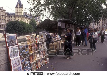 Stock Image -  Paris, France, Europe, People [browsing, looking] at postcards, art, and books along the quais of Rive Gauche (Left Bank) of the Seine River in Paris.. Fotosearch