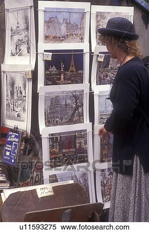 Paris, France, Europe, Woman looking at prints for sale on a rack along the quais of Rive Gauche (Left Bank) of the Seine River in Paris. View Large Photo Image Stock Photography - Paris, France, Europe, Woman looking at prints for sale on a rack along the quais of Rive Gauche (Left Bank) of the Seine River in Paris.. Fotosearch