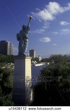 Stock Image -  Paris, Statue of Liberty, France, Europe, Seine River, A miniature replica of the Statue of Liberty towers above the Seine River in Paris.. Fotosearch