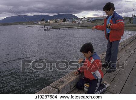 Patagonia, Chile, Pacific Ocean, Two boys fishing off pier in Puerto Natales in Chile. View Large Photo Image Picture - Patagonia, Chile, Pacific Ocean, Two boys fishing off pier in Puerto Natales in Chile. . Fotosearch