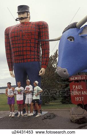 Stock Image -  Paul Bunyan, Minnesota, Four teenage boys stand posing for a picture in front of giant Paul Bunyan and Babe the Blue Ox Statues in the town of Bemidji in the state of Minnesota . Fotosearch