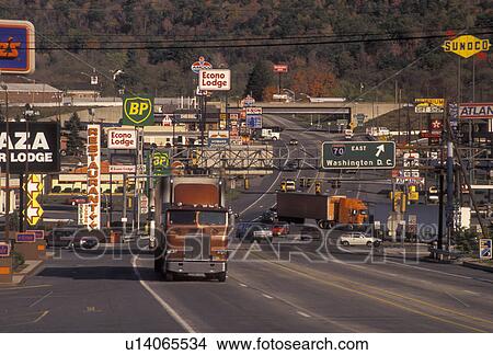 Picture -  Pennsylvania, Truck driving up Route 30 with signs, advertisements, and billboards on both sides of the highway in Breezewood (intersection of PA Turnpike I76, I70 and I99) in the state of Pennsylvania. . Fotosearch