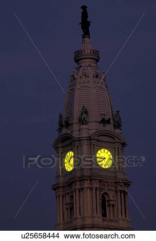 Picture -  Philadelphia, city hall, Pennsylvania, William Penn stands on top of the clock tower of City Hall in downtown Philadelphia at night in the state of Pennsylvania. . Fotosearch