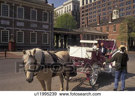 Stock Photo -  Philadelphia, Independence Park, horse-drawn carriage, Independence National Historical Park, Pennsylvania, Horse-drawn carriage picking up tourists in front of Independence Hall in Independence Nat'l Historical Park in Philadelphia in the state of Penns. Fotosearch