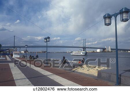 Philadelphia, Penn's Landing, Pennsylvania, Historic Penn's Landing riverfront on the Delaware River with the Benjamin Franklin Bridge in the distance in Philadelphia, Pennsylvania. View Large Photo Image Stock Photograph - Philadelphia, Penn's Landing, Pennsylvania, Historic Penn's Landing riverfront on the Delaware River with the Benjamin Franklin Bridge in the distance in Philadelphia, Pennsylvania.. Fotosearch