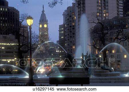 Stock Photography -  Philadelphia, Pennsylvania, Fountain at Logan Circle with City Hall in the background in the evening indowntown Philadelphia, Pennsylvania. The fountain was cast by Alexander Stirling Calder.. Fotosearch