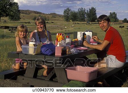 Stock Image -  picnicking, family, outdoor, recreation, Montana, Family eating together at picnic table in Lewis & Clark Caverns State Park Campground.. Fotosearch