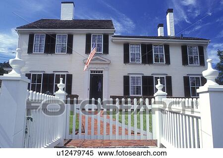 Plymouth, Massachusetts, The majestic colonial white house with a white picket fence stands along the Historic Plymouth District. An American flag is hanging from the window View Large Photo Image Stock Photography - Plymouth, Massachusetts, The majestic colonial white house with a white picket fence stands along the Historic Plymouth District. An American flag is hanging from the window . Fotosearch