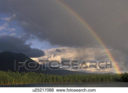 Stock Photo -  rainbow, lake, Maine, Baxter State Park, Rainbow over Daicey Pond after a thunderstorm. Mt. Katahdin in the background in Baxter State Park. . Fotosearch