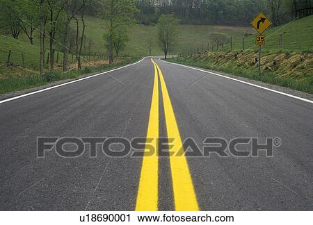 Stock Image -  road, Highway, yellow lines, Tennessee, An isolated Route 129 with bright double yellow lines winds through the countryside in the state of Tennessee.. Fotosearch