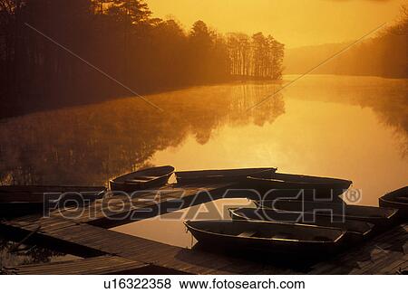 Stock Photo -  rowboats, Stone Mountain, sunrise, sunset, lake, Atlanta, Stone Mountain Park, Georgia, Rowboats at sunrise on Venable Lake in Georgia's Stone Mountain Park near Atlanta in the state of Georgia.. Fotosearch