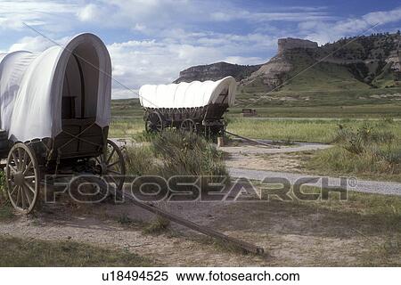 Stock Photography -  Scotts Bluff, Nebraska, Covered wagon exhibits with wind-sculpted bluff in background at Scotts Bluff National Monument., . Fotosearch