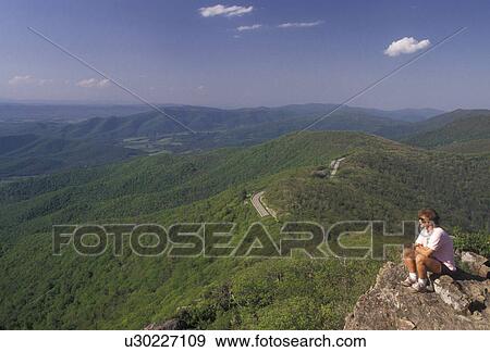 Shenandoah National Park, overlook, hiking, summit, Appalachian Trail, Blue Ridge, Appalachian Mountains, Skyline Drive, Virginia, Woman sits at overlook along the Appalachian Trail (a National Scenic Trail) in the Shenandoah Nat'l Park in the state of V View Large Photo Image Stock Photo - Shenandoah National Park, overlook, hiking, summit, Appalachian Trail, Blue Ridge, Appalachian Mountains, Skyline Drive, Virginia, Woman sits at overlook along the Appalachian Trail (a National Scenic Trail) in the Shenandoah Nat'l Park in the state of V. Fotosearch