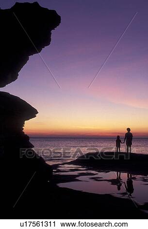 Stock Image -  silhouette, Lake Superior, Pictured Rocks, sunset, sunrise, Upper Peninsula, U. P Michigan, Mother and daughter standing on the edge of Lake Superior at sunset at Pictured Rocks National Lakeshore in Munising in the state of Michigan.. Fotosearch