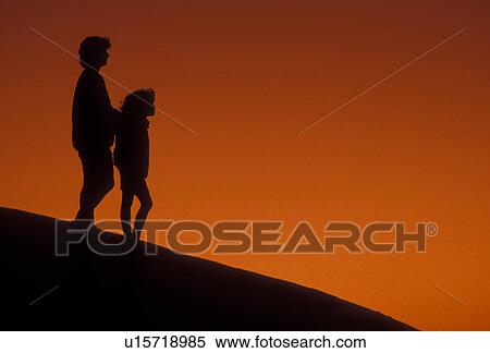 Stock Photography -  Silhouette, overlook, people, Stone Mountain, Georgia's Stone Mountain Park, Atlanta, Georgia, Silhouette of mother and young daughter at sunset on the summit of Stone Mountain in Georgia's Stone Mt. Park near Atlanta in the state of Georgia. . Fotosearch