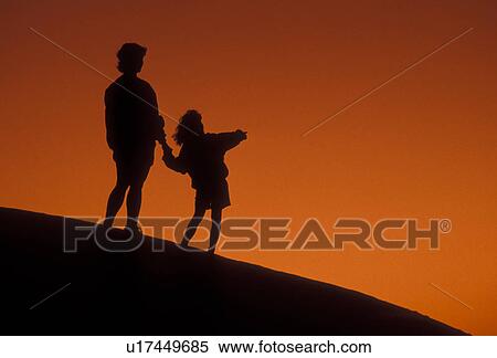 Stock Photography -  Silhouette, people, overlook, Stone Mountain, Georgia's Stone Mountain Park, Atlanta, Georgia, Silhouette of mother and young daughter holding hands and looking/watching at sunset on the summit of Stone Mountain in Georgia's Stone Mt. Park near Atlanta i. Fotosearch
