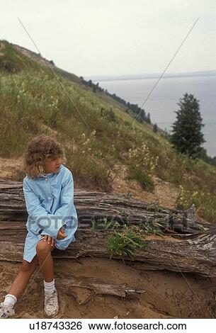 Sleeping Bear Dunes, hiking, trail, Michigan, Young girl sitting alone on an old log at Empire Bluff looking out over Lake Michigan at Sleeping Bear Dunes National Lakeshore in the state of Michigan. View Large Photo Image Stock Photograph - Sleeping Bear Dunes, hiking, trail, Michigan, Young girl sitting alone on an old log at Empire Bluff looking out over Lake Michigan at Sleeping Bear Dunes National Lakeshore in the state of Michigan.. Fotosearch