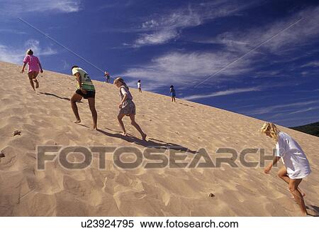 Sleeping Bear Dunes, sand dune, dune climb, Michigan, People climbing up the steep large sand dune (a perched dune) at Sleeping Bear Dunes National Lakeshore in the state of Michigan. View Large Photo Image Stock Photography - Sleeping Bear Dunes, sand dune, dune climb, Michigan, People climbing up the steep large sand dune (a perched dune) at Sleeping Bear Dunes National Lakeshore in the state of Michigan.. Fotosearch