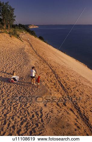 Sleeping Bear Dunes, sand dune, Lake Michigan, Michigan, People looking over the edge of a steep sand dune (a perched dune) along Lake Michigan at Sleeping Bear Dunes National Lakeshore in the state of Michigan. View Large Photo Image Stock Photo - Sleeping Bear Dunes, sand dune, Lake Michigan, Michigan, People looking over the edge of a steep sand dune (a perched dune) along Lake Michigan at Sleeping Bear Dunes National Lakeshore in the state of Michigan.. Fotosearch