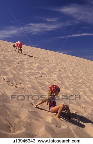 Sleeping Bear Dunes, sand dune, Michigan, Young girl sliding down the steep towering sand dune (a perched dune) at Sleeping Bear Dunes National Lakeshore in the state of Michigan. View Large Photo Image Stock Image - Sleeping Bear Dunes, sand dune, Michigan, Young girl sliding down the steep towering sand dune (a perched dune) at Sleeping Bear Dunes National Lakeshore in the state of Michigan.. Fotosearch