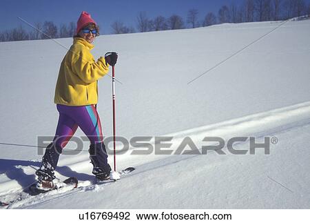 Stock Image -  snowshoeing, Vermont, Montpelier, VT, Woman snowshoeing in winter.. Fotosearch