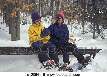 Stock Photograph -  snowshoeing, Vermont, VT, Mother and daughter take a break from snowshoeing in Groton State Forest in winter.. Fotosearch