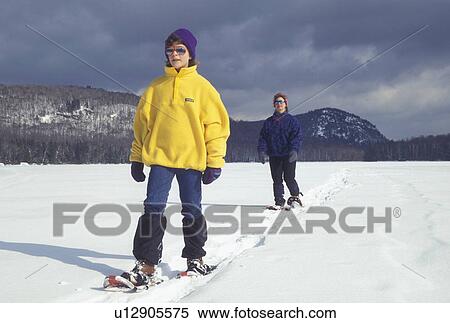 snowshoeing, Vermont, VT, Mother and daughter snowshoeing on the frozen Kettle Pond in Groton State Forest in winter. View Large Photo Image Stock Photography - snowshoeing, Vermont, VT, Mother and daughter snowshoeing on the frozen Kettle Pond in Groton State Forest in winter.. Fotosearch