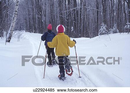 Stock Photography -  snowshoeing, Vermont, VT, Mother and daughter snowshoeing on a snow-covered trail in Groton State Forest in winter.. Fotosearch