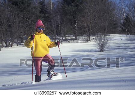 snowshoeing, Vermont, VT, Woman snowshoeing with ski poles in deep snow in winter in Montpelier. View Large Photo Image Stock Photo - snowshoeing, Vermont, VT, Woman snowshoeing with ski poles in deep snow in winter in Montpelier.. Fotosearch