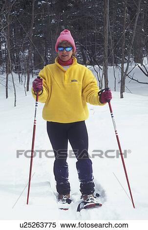 snowshoeing, winter, Vermont, VT, Woman snowshoeing using ski poles in a snow-covered field in winter in Montpelier. View Large Photo Image Stock Photography - snowshoeing, winter, Vermont, VT, Woman snowshoeing using ski poles in a snow-covered field in winter in Montpelier.. Fotosearch
