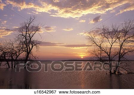Stock Photo -  South Dakota, [Sunrise, sunset] over lake at Waubay National Wildlife Refuge. Home to many species of birds and mammals . Fotosearch