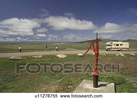 Stock Photography -  South Dakota, water pump, Belle Fourche, Geographical Center of United States, A red water pump at the Geographical Center of the United States in Belle Fourche in the state of South Dakota. . Fotosearch