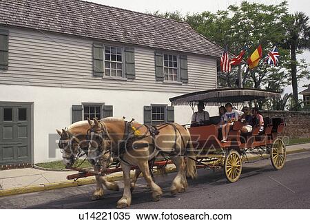 Stock Photography -  St. Augustine, horse-drawn carriage, Florida, Horse-drawn carriage passes in front of the oldest house, the Gonzalez-Alvarez House, in Saint Augustine in the state of Florida. St. Augustine is the oldest settlement in the United States.. Fotosearch