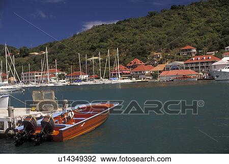 Stock Image -  St. Barts, Caribbean, St. Barthelemy, Gustavia, Saint Barts, Caribbean Islands, Boat docked in the scenic harbor of Gustavia the capital of the island of Saint Barthelemy (a department of Guadeloupe).. Fotosearch
