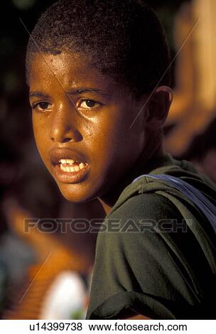 Stock Photo -  St. Martin, Caribbean, Caribbean Islands, Local black boy watching a parade during the carnival in Marigot the French capital of the island of Saint Martin (french part).. Fotosearch