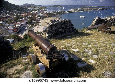 Stock Image -  St. Martin, Caribbean, Marigot, Caribbean Islands, Scenic view of Nettle Bay and Marigot the French capital of the island Saint Martin (french part) from Fort St. Louis. A cannon guards the city. Fotosearch