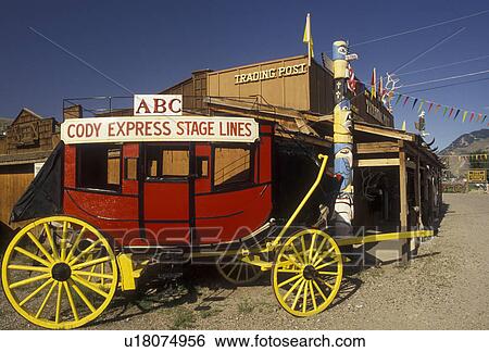 stage coach, Cody, Wyoming, A red stage coach of ABC Cody Express Stage Lines is parked in front of an old trading post in Cody in the state of Wyoming. View Large Photo Image Stock Photograph - stage coach, Cody, Wyoming, A red stage coach of ABC Cody Express Stage Lines is parked in front of an old trading post in Cody in the state of Wyoming. . Fotosearch