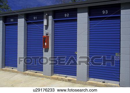 storage units, A red fire extinquisher hangs on the wall next to the blue doors of storage units. View Large Photo Image Stock Image - storage units, A red fire extinquisher hangs on the wall next to the blue doors of storage units.. Fotosearch