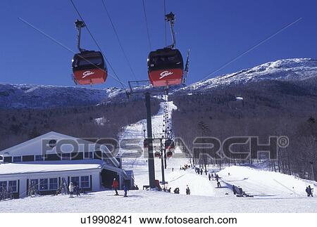 Stock Image -  Stowe, skiing, Vermont, VT, Red gondolas and skiing on the slopes at Stowe Ski Area at Stowe Mountain Resort in Stowe in the snow in winter.. Fotosearch