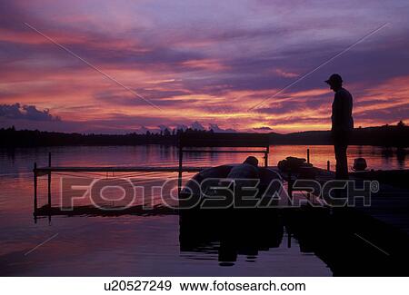 sunrise, sunset, lake, Upper Peninsula, U. P Michigan, Silhouette of fishermen down by the dock at sunset over the calm waters of Ruth Lake in Three Lakes in the state of Michigan. View Large Photo Image Stock Photo - sunrise, sunset, lake, Upper Peninsula, U. P Michigan, Silhouette of fishermen down by the dock at sunset over the calm waters of Ruth Lake in Three Lakes in the state of Michigan.. Fotosearch