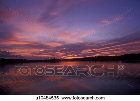 Stock Photography -  sunrise, sunset, lake, Upper Peninsula, U. P Michigan, Scenic view of the sunset over the calm waters of Ruth Lake in Three Lakes in the state of Michigan.. Fotosearch