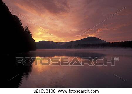 sunrise, sunset, Vermont, The beautiful orange sky reflects in the calm waters of Molly Falls Pond at sunrise in Marshfield in Washington County in the state of Vermont. View Large Photo Image Stock Photo - sunrise, sunset, Vermont, The beautiful orange sky reflects in the calm waters of Molly Falls Pond at sunrise in Marshfield in Washington County in the state of Vermont. . Fotosearch