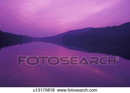 sunset, lake, Vermont, The purple sky reflects in the calm waters of Kettle Pond at sunset in Groton State Forest in Caledonia County in the state of Vermont. View Large Photo Image Stock Photo - sunset, lake, Vermont, The purple sky reflects in the calm waters of Kettle Pond at sunset in Groton State Forest in Caledonia County in the state of Vermont. . Fotosearch