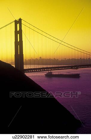The Golden Gate Bridge, San Francisco, San Francisco Bay, Pacific Ocean, California, Barge goes under The Golden Gate Bridge of San Francisco at sunrise, the longest single-span suspension bridges ever built, in the state of California. (yellow/purple fi View Large Photo Image Stock Image - The Golden Gate Bridge, San Francisco, San Francisco Bay, Pacific Ocean, California, Barge goes under The Golden Gate Bridge of San Francisco at sunrise, the longest single-span suspension bridges ever built, in the state of California. (yellow/purple fi. Fotosearch