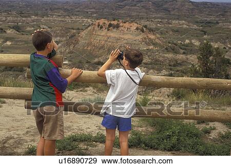 Theodore Roosevelt National Park, South Unit, North Dakota, overlook, Two boys looking at the view of the badlands from the overlook at the Painted Canyon Visitors Center at Theodore Roosevelt National Park in the South Unit in the state of North Dakota. View Large Photo Image Stock Photo - Theodore Roosevelt National Park, South Unit, North Dakota, overlook, Two boys looking at the view of the badlands from the overlook at the Painted Canyon Visitors Center at Theodore Roosevelt National Park in the South Unit in the state of North Dakota.. Fotosearch