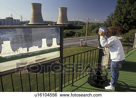 Three Mile Island, nuclear power, Pennsylvania, A woman looks through the binoculars at Three Mile Island Nuclear Power Plant from the observation deck at the Energy Education Center in Middletown in the state of Pennsylvania. View Large Photo Image Stock Photograph - Three Mile Island, nuclear power, Pennsylvania, A woman looks through the binoculars at Three Mile Island Nuclear Power Plant from the observation deck at the Energy Education Center in Middletown in the state of Pennsylvania.. Fotosearch