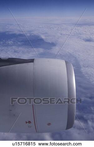 Stock Photography -  Trans Atlantic Flight, Air Lingus airline flying above the clouds, airplane engine in view . Fotosearch
