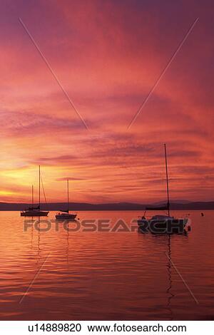 Stock Image -  Vermont, Lake Champlain, Sailboats float on the quiet calm waters of [sunrise, sunset] at Appletree Marina on Lake Champlain in South Hero.. Fotosearch
